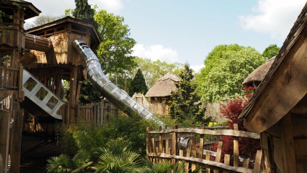 The planting around the slides with thatched roofs in the background at Windsor Great Park Adventure Play LEAD