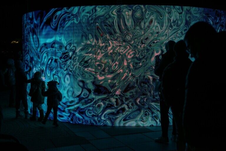 A group of people ion front of an LED wall