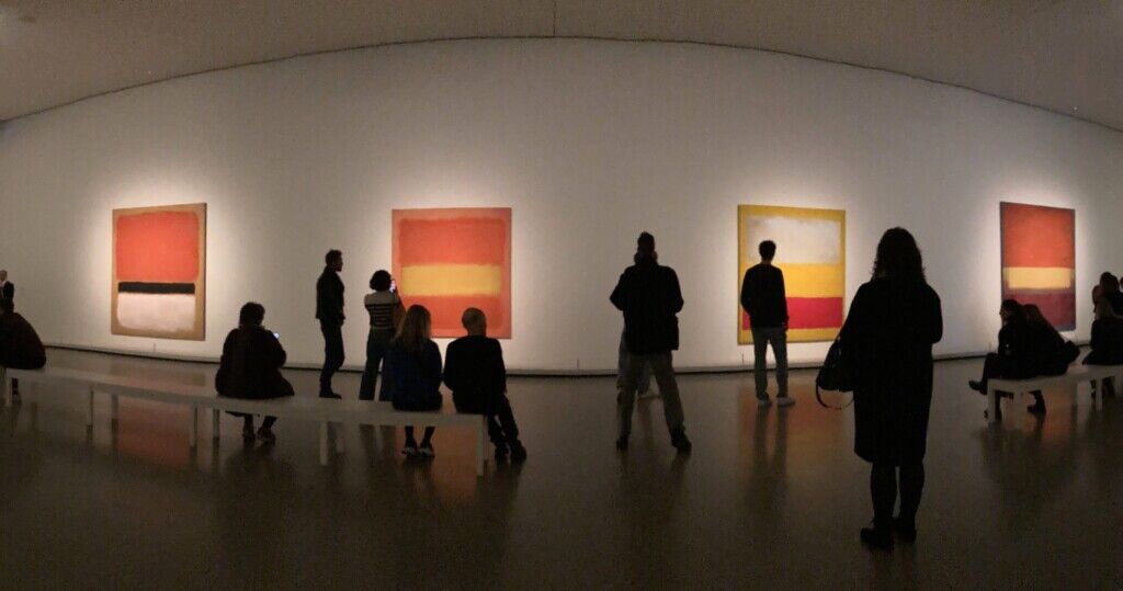ICOM UK. Silhouettes of people in a gallery, stood in front of a wall of art